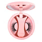 Pink round magnetic lash case open to show the applicator clip and a pair of black lashes
