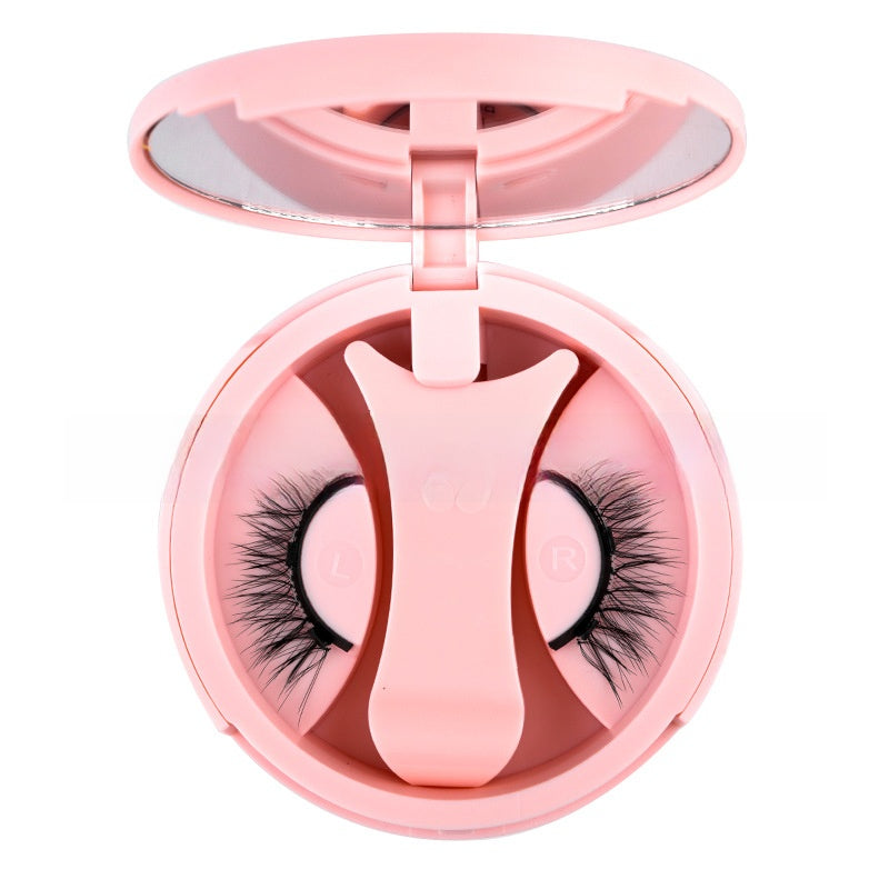 Pink round magnetic lash case open to show the applicator clip and a pair of black lashes