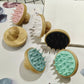 Group of round bamboo scalp brushes with flexible silicone bristles arranged on a white board