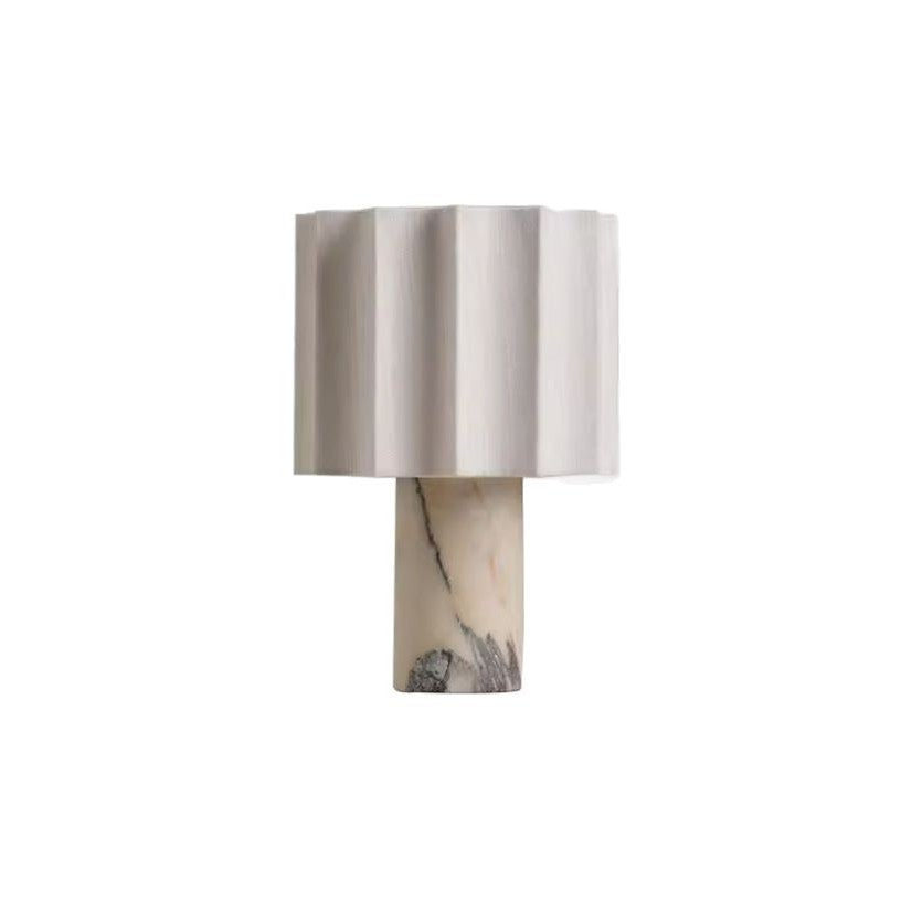 White marble table lamp with a fluted linen shade on a plain background