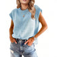 Woman wearing a solid color round neck cap sleeve knit top with a relaxed drape over denim shorts