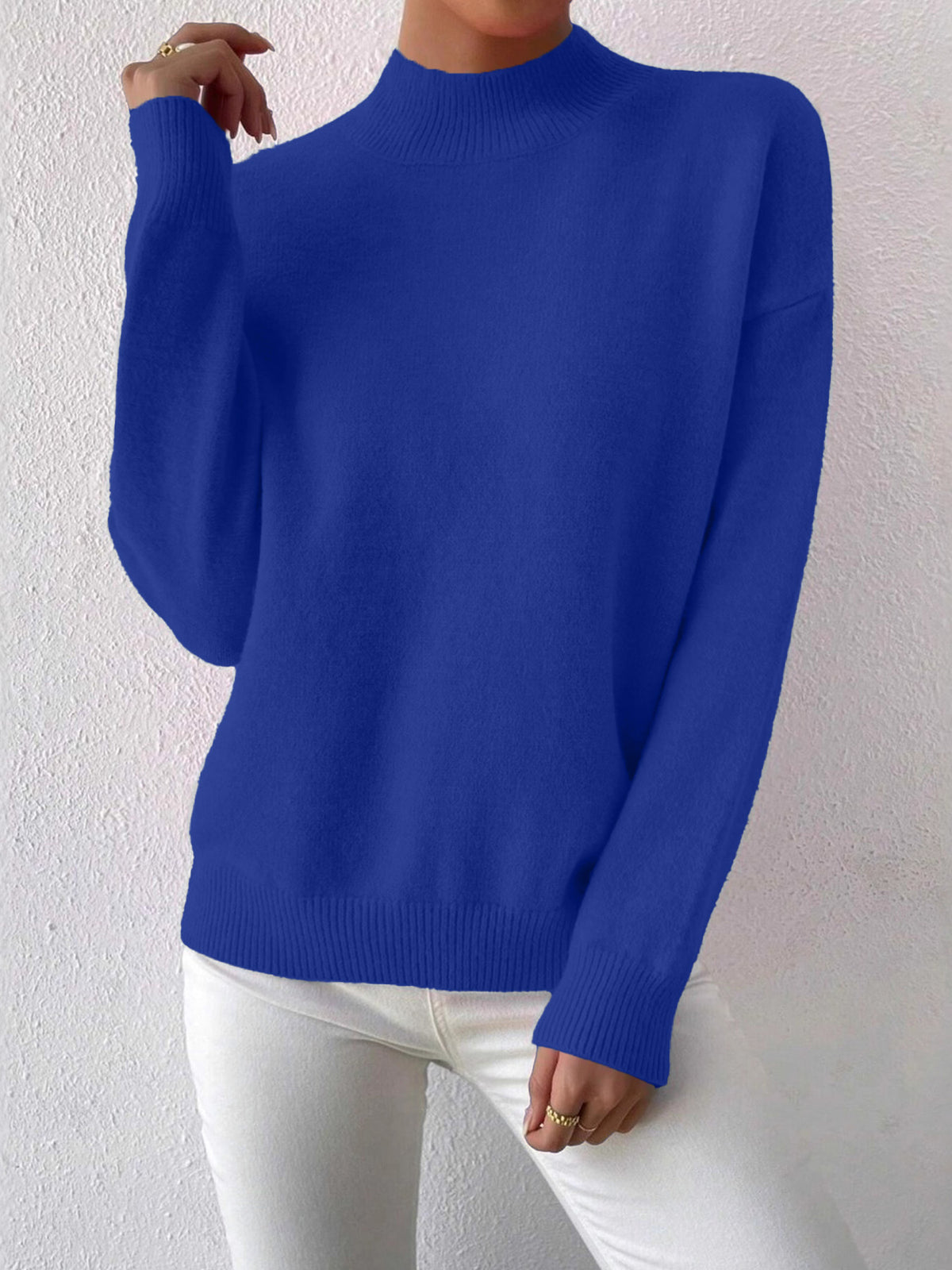 Woman wearing a royal blue half-high neck pullover sweater with long sleeves and a ribbed hem