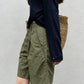 Side profile of army green pleated Bermuda shorts showing belt loops and slanted side pocket