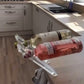 Two wine bottles tilted on clear acrylic holders in a kitchen, option image for the 1 pack Transparent option