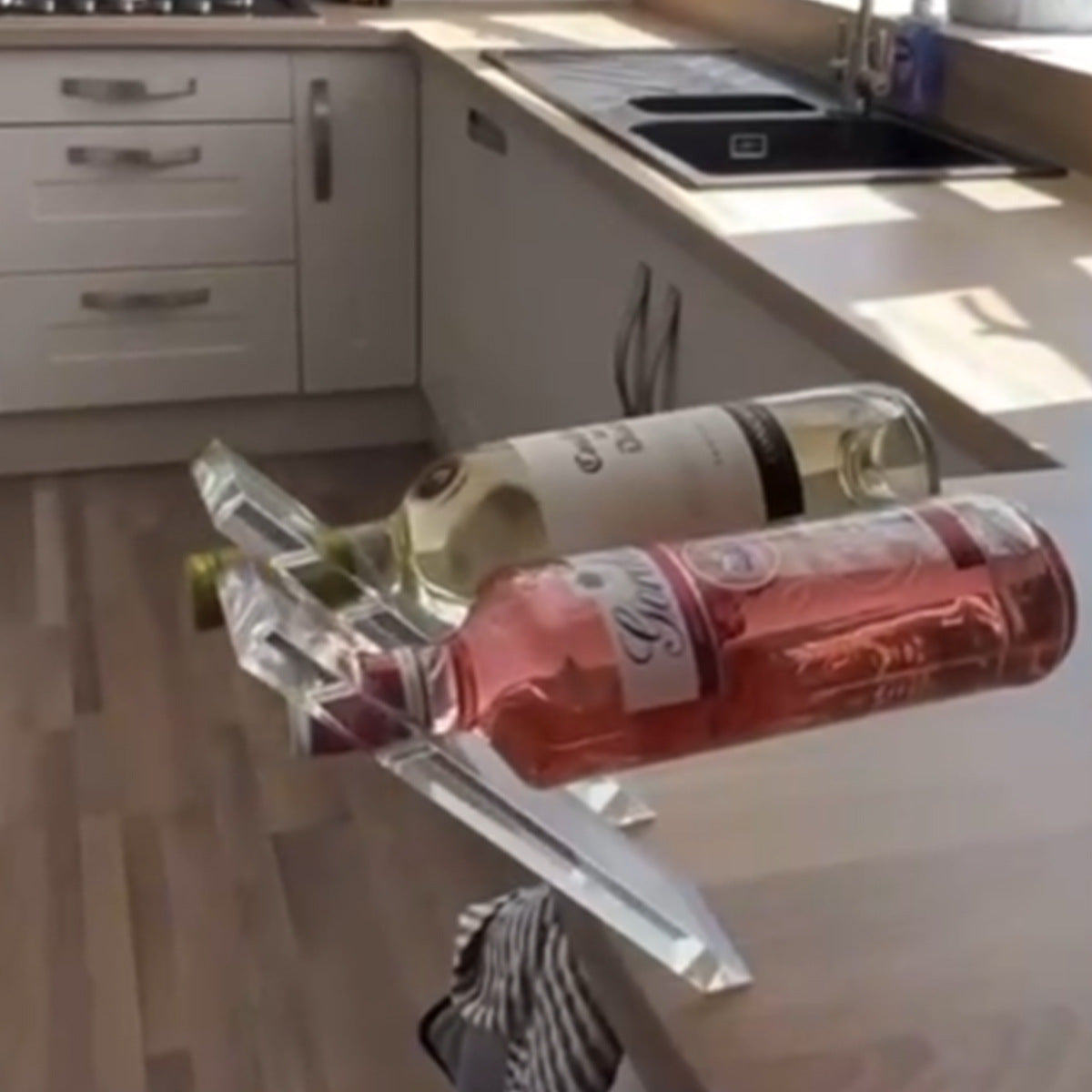 Two wine bottles tilted on clear acrylic holders in a kitchen, option image for the 1 pack Transparent option