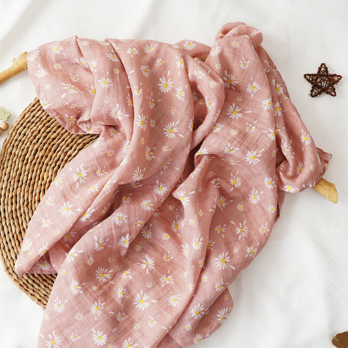 Pure cotton muslin swaddle blanket rolled up, showing the airy gauze texture and printed design
