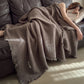 Dark Chestnut Brown cotton gauze throw blanket with tassel fringe, draped over a woman asleep on a dark sofa, view 4 of 4