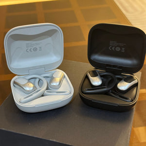 Silver and black flip charging cases open with the open ear earphones resting inside