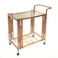 Close view of a swivel caster wheel under the gold toned stainless steel serving cart