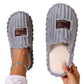 Gray ribbed plush slippers with a cream plush lining and a label patch on a white background