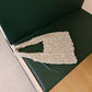 Close up of the open crochet net and woven in pearl beads on the bag