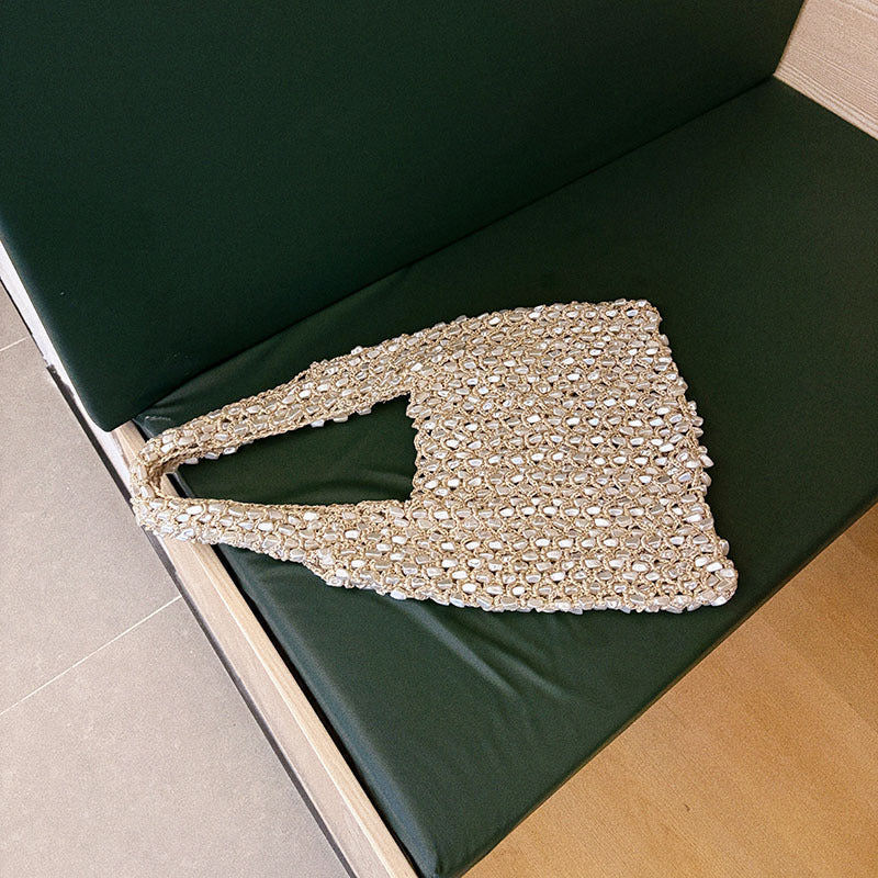 Close up of the open crochet net and woven in pearl beads on the bag