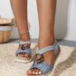 Dusty blue wedge hemp sandal with chrome ring and jute platform, styled on a fibre mat