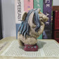 Side view of troll statue showing sculpted hair and wine colored boots