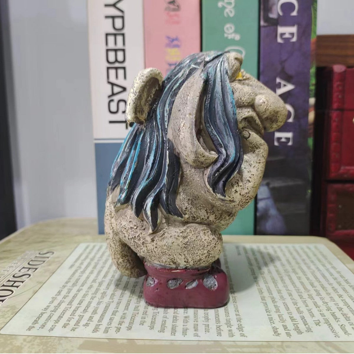 Side view of troll statue showing sculpted hair and wine colored boots