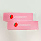 Two pink strawberry bar squishy toys with a strawberry print and the word strawberry