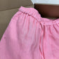Close up of pink linen shorts elastic waistband and thin self-fabric front tie