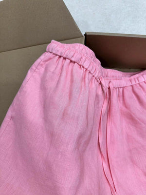 Close up of pink linen shorts elastic waistband and thin self-fabric front tie