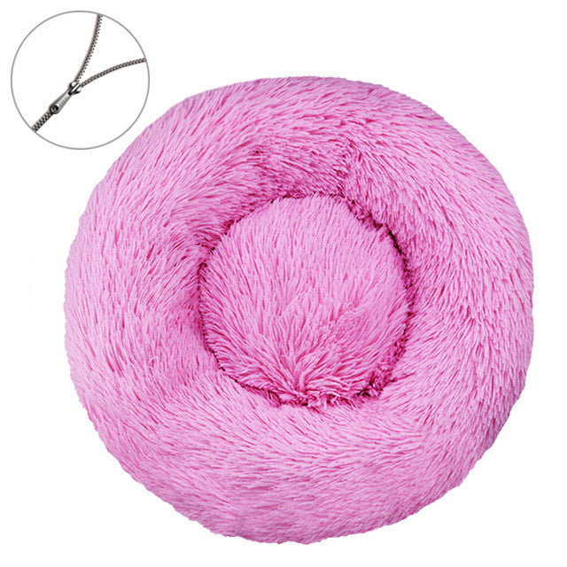 Pink round plush pet bed with a raised bolster rim on a plain background
