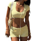 Pale yellow crop top and fold-over shorts worn with a tote bag and white earphones on the street