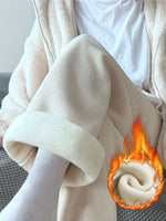 Cream wide-leg corduroy pants with a plush fleece lining visible at the turned-up cuff, worn with a white tee