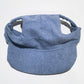 Small dog wearing the corduroy baseball cap with the brim at the front