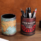 Round vintage pen cups with a world map and a Premium 1982 Heritage print holding pens on a wooden table