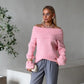 Pink off-shoulder fold-over knit sweater worn with grey trousers and a pearl necklace