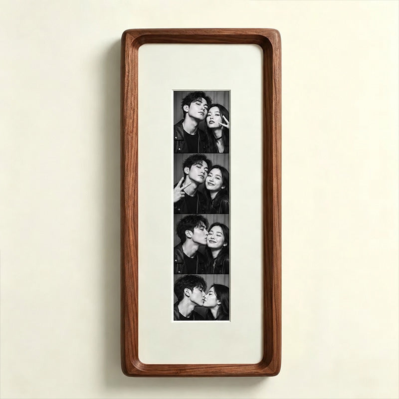 Walnut photo strip frame with classic almond white lining and a tempered glass front on a cream wall
