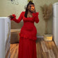 Woman in a red long sleeve maxi dress with ruffled cuffs, hip rosettes and a mesh skirt taking a mirror selfie