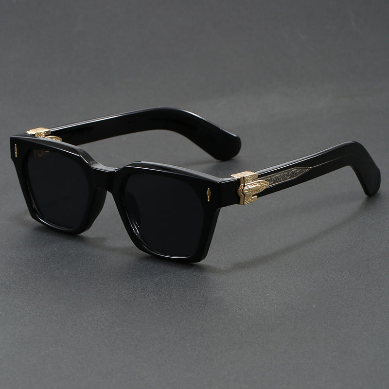 Sand white framed square sunglasses with an emerald tinted lens on a grey surface