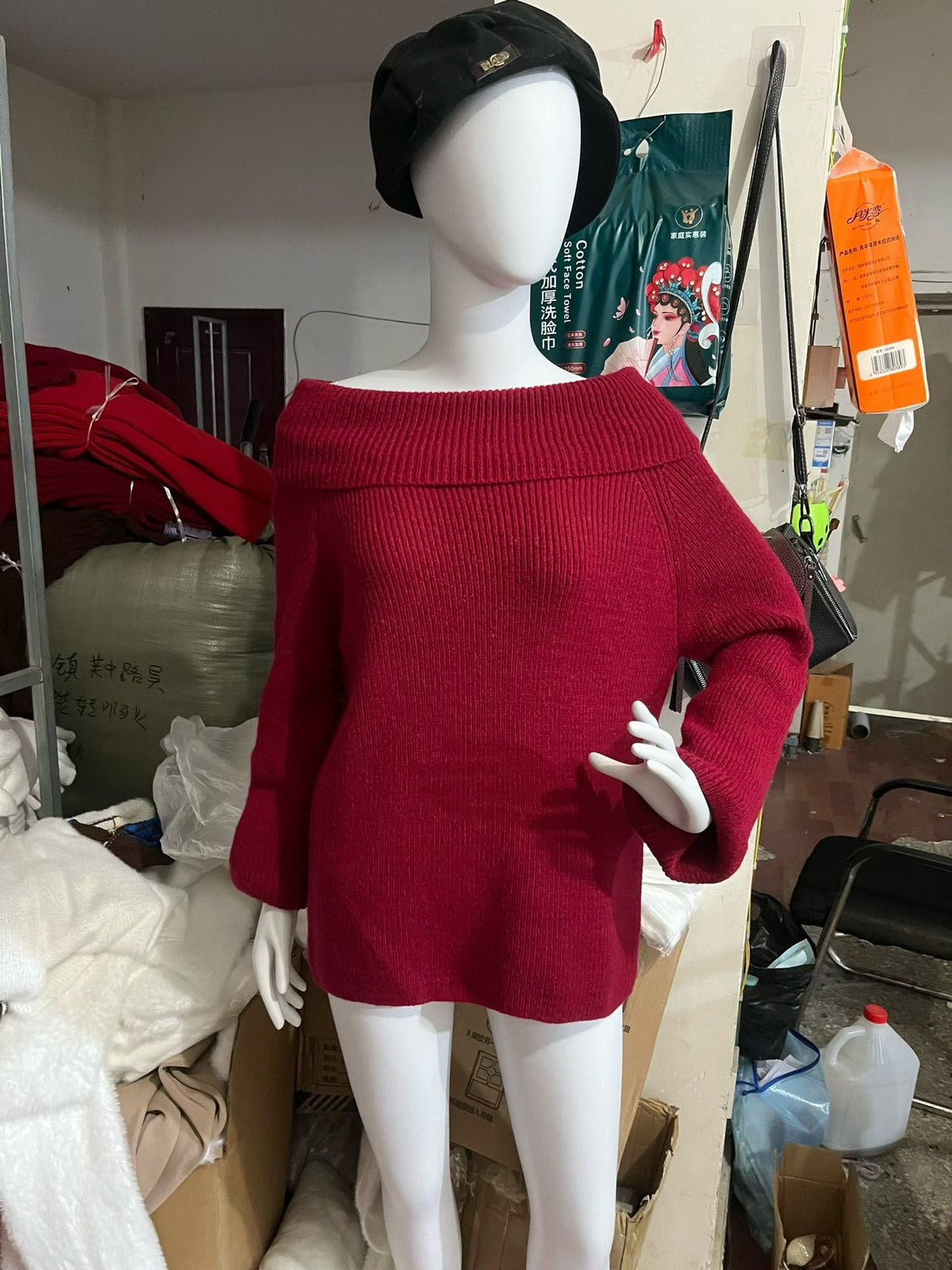 Deep red off-shoulder knit sweater with wide sleeves shown on a mannequin