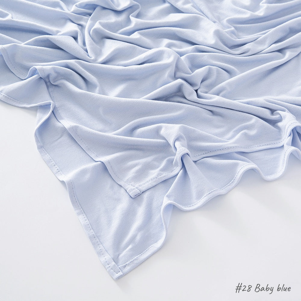 Corner of the modal cotton headscarf wrap showing the neat rolled hem and flat solid color
