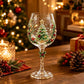 Clear wine goblet with a painted Christmas tree and holly design on the bowl