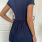 Navy babydoll top showing the surplice V-neck and gathered empire waist on a model
