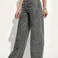 Hanging pair of straight leg jeans by a window in soft daylight