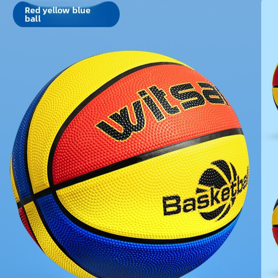 Red yellow and blue paneled kids basketball shown close up on a blue studio block