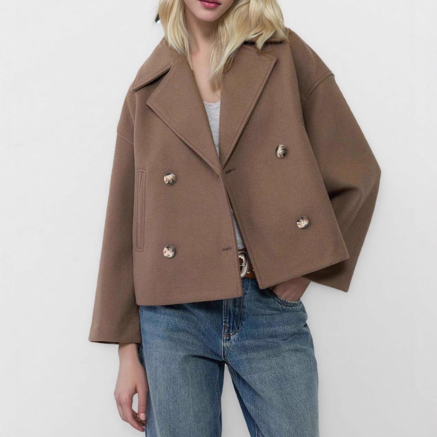 White cropped double breasted wool blend coat buttoned with notch lapels on a model
