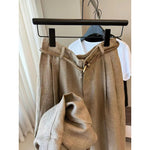 Khaki wide-leg summer pants on a hanger with a braided cord belt and gold ring