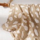 Soft cotton muslin gauze baby blanket shown folded, revealing the light open double layer weave