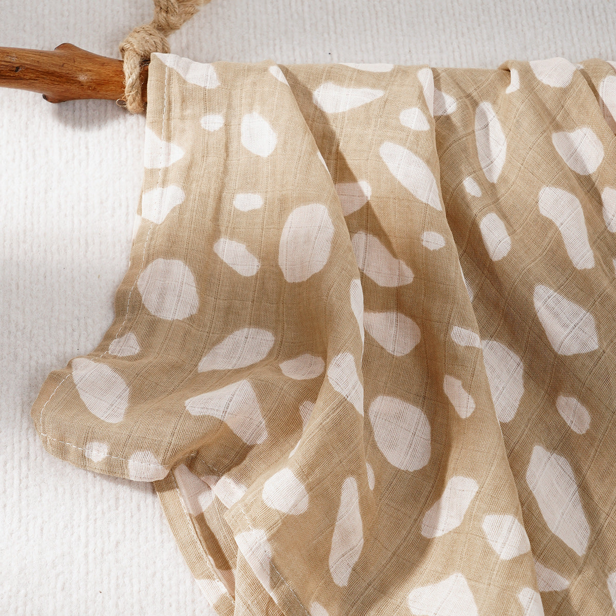 Soft cotton muslin gauze baby blanket shown folded, revealing the light open double layer weave