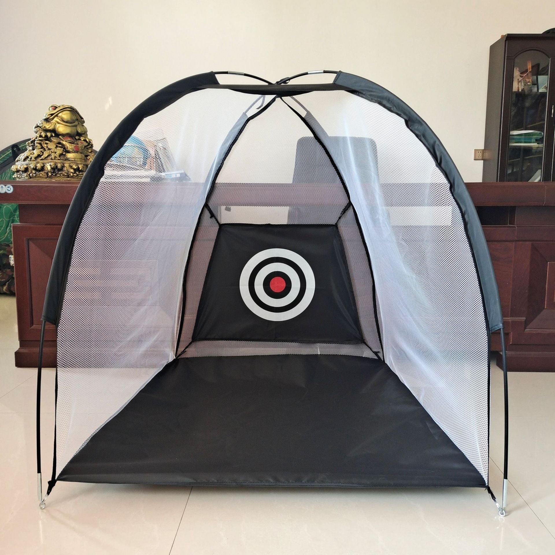 Golfer hitting a ball into the indoor practice net during a home session