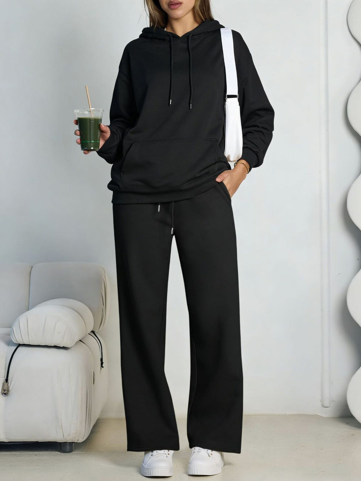 Black fleece hooded sweatshirt and wide-leg sweatpants set worn by a model
