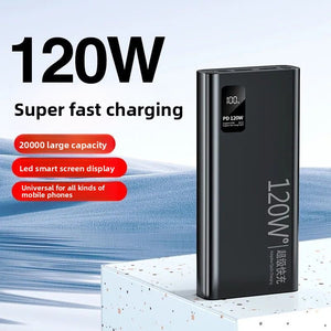 Black power bank marked 120W standing on a block with the percentage display