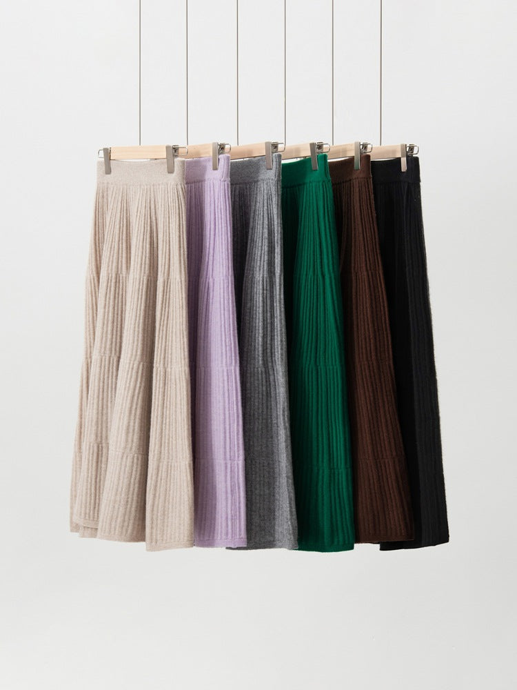Six ribbed knit midi skirts hanging side by side in beige, lilac, gray, green, brown and black