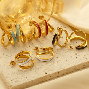 Five gold plated C-shaped enamel hoop earrings in teal red black and white on stone