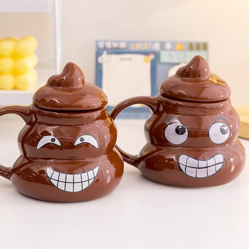 Two brown ceramic poop emoji mugs, one winking and one grinning, with rounded C handles