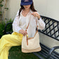 Open weave woven shoulder bag in cream with tan stripe bands and gold buckles
