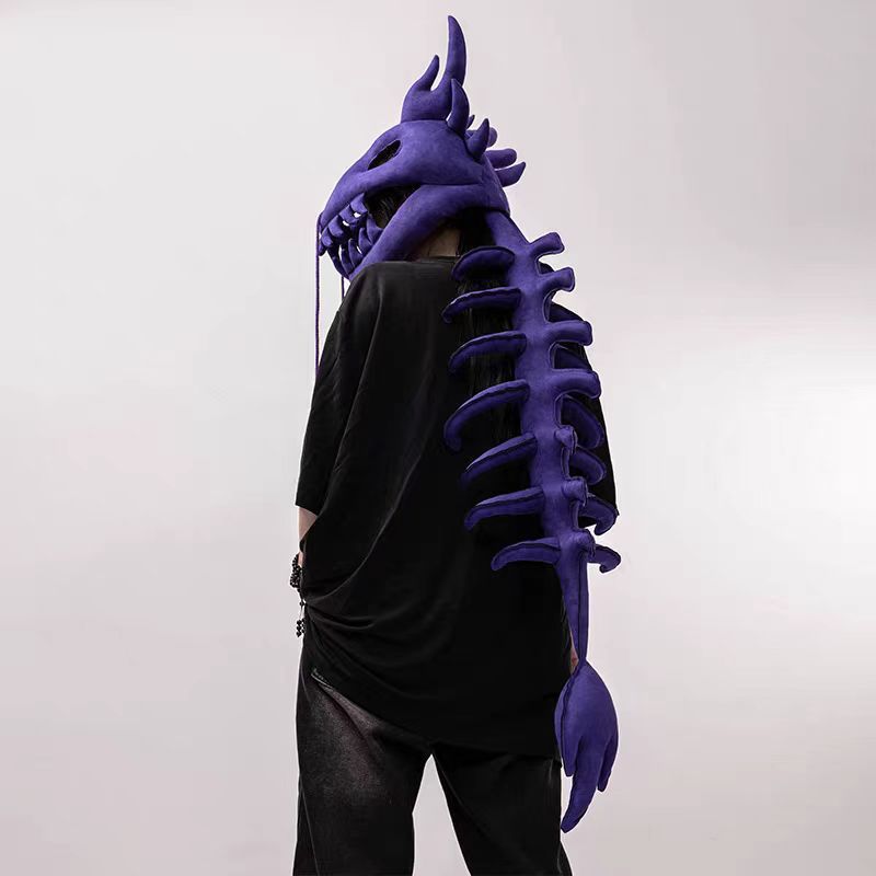 Plush dinosaur skeleton headgear with open jaw teeth and a long padded backbone tail for dress-up