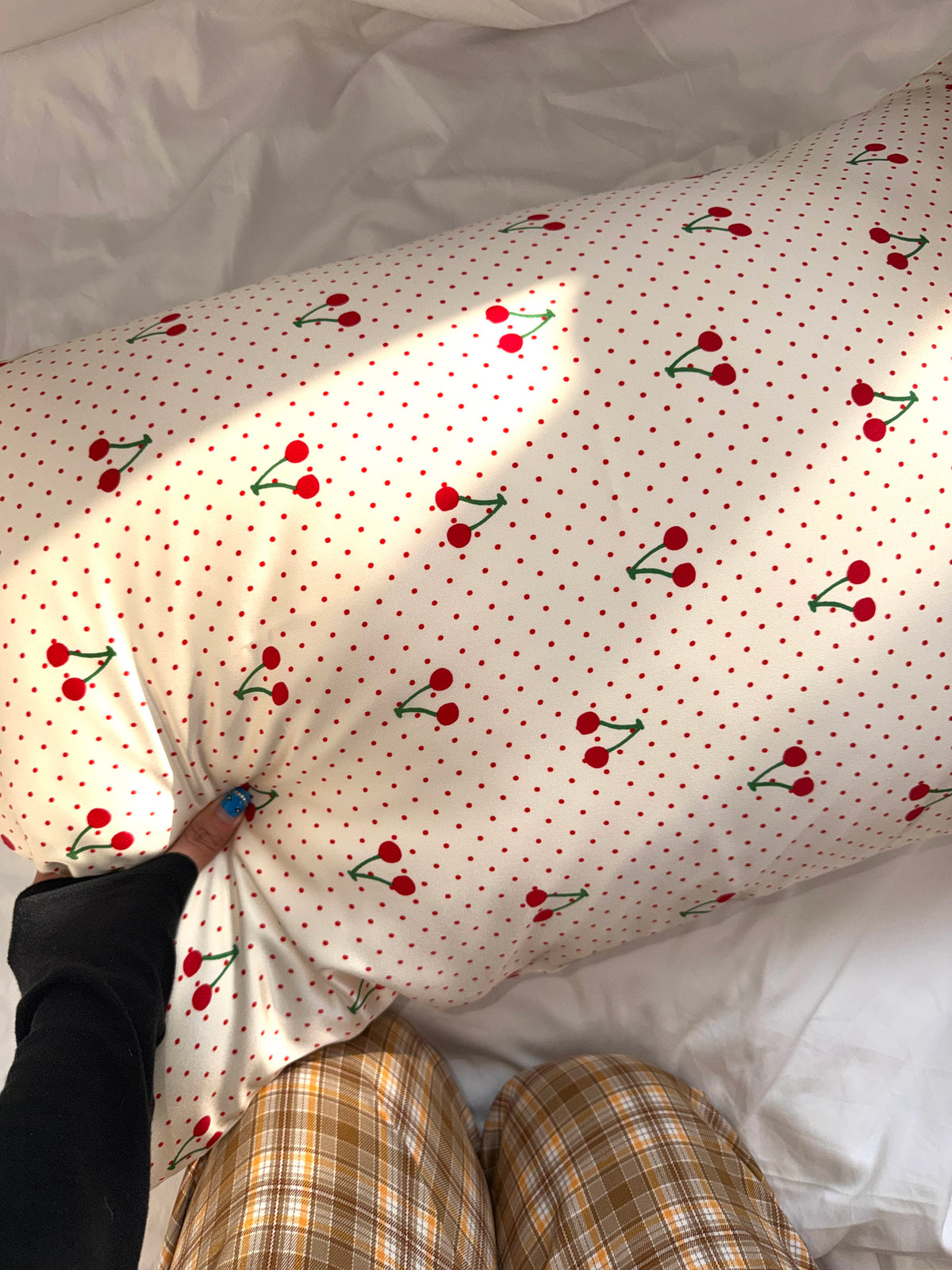 Cherry dot silk pillowcase with red cherries on white, hand pressing the fabric